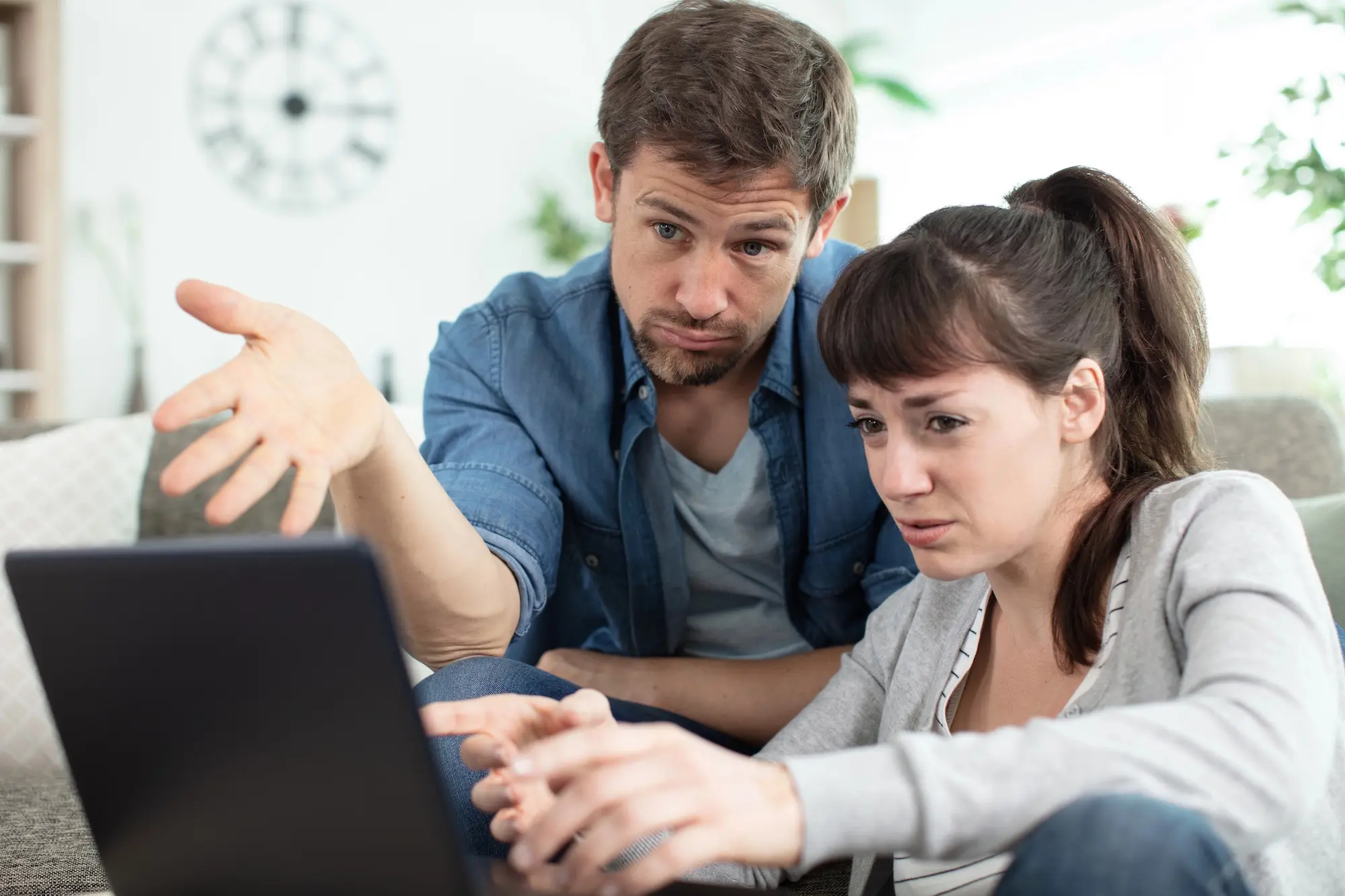 Frustrated couple reviewing a rental scam on their laptop
