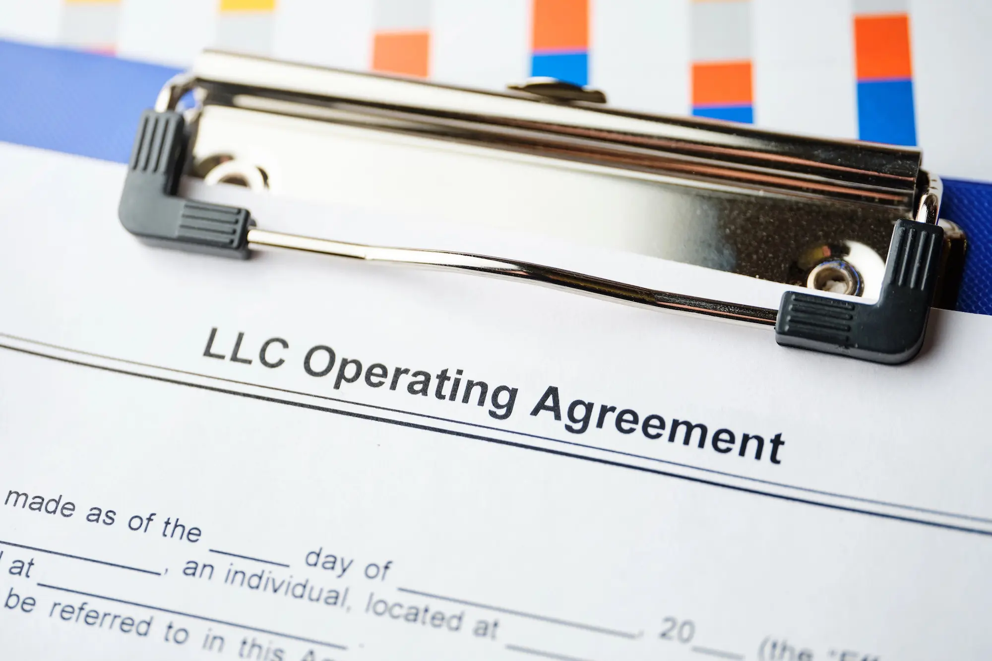 Close-up of an LLC Operating Agreement on a clipboard, representing legal protection for rental property owners