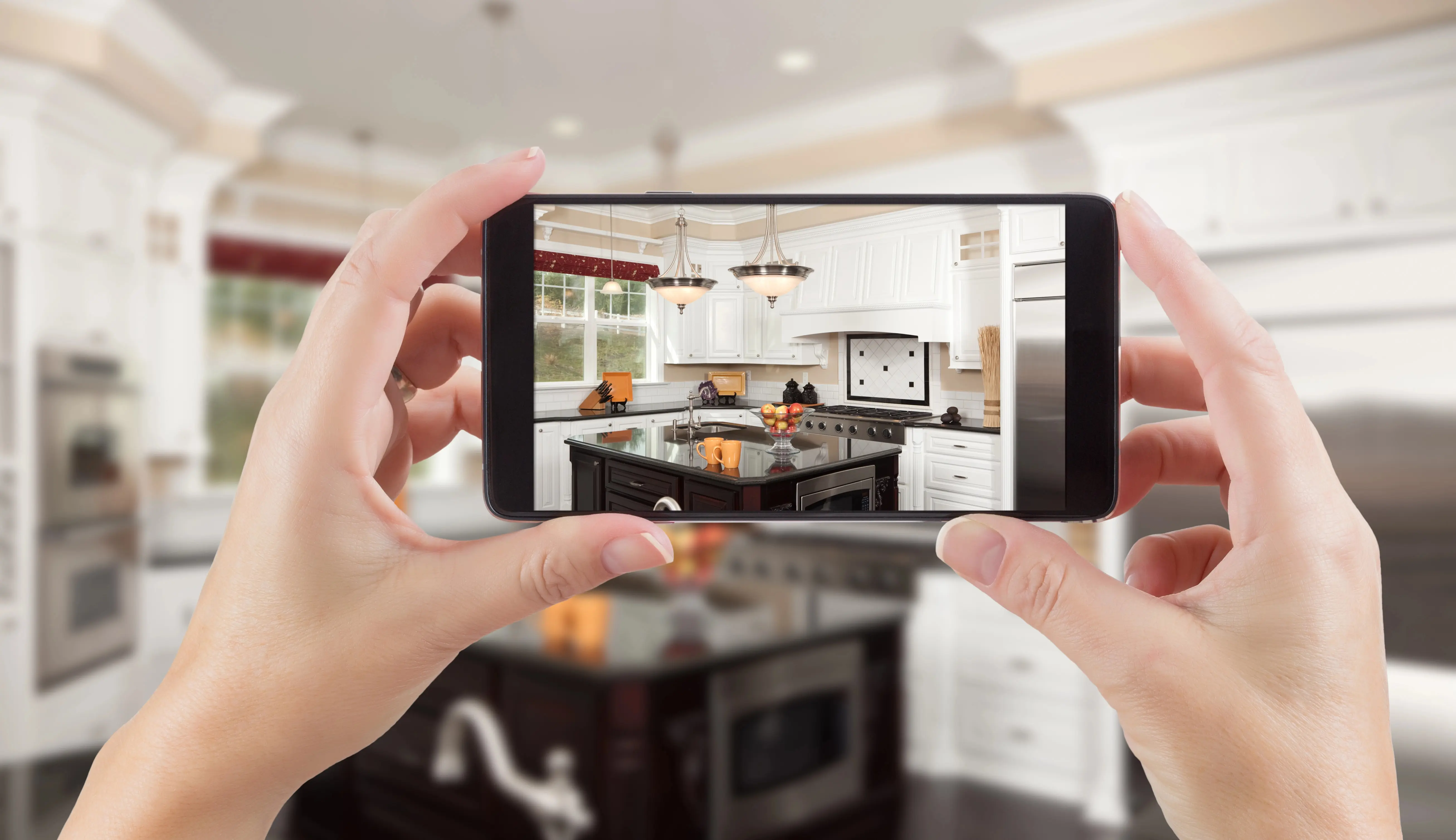 Hands taking a photo of a rental kitchen with a smartphone for move-in documentation