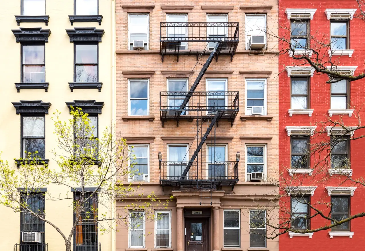 Historic apartment building with fire escapes and window air conditioners